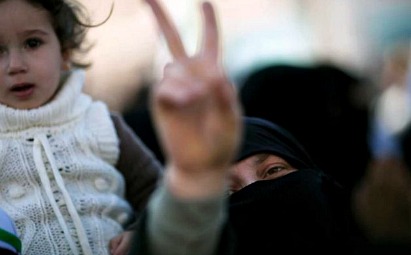 A woman displays a victory sign during an anti-government demonstration in Idlib, 2012. (FreedomHouse / Flickr)
